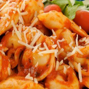 Closeup of a plate of cheese tortellini with marinara sauce